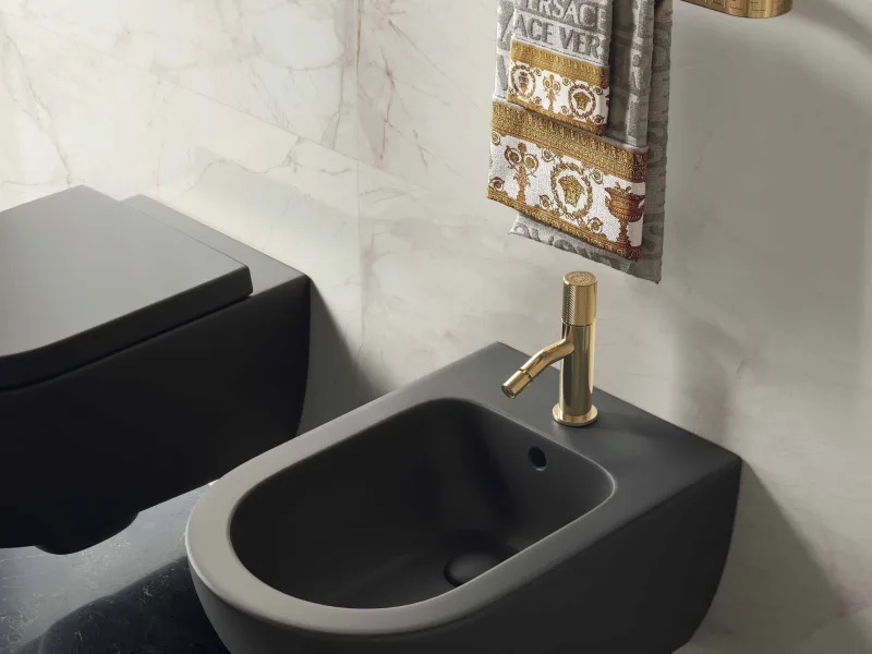 Złota bateria bidetowa Cannetè przy czarnej ceramice