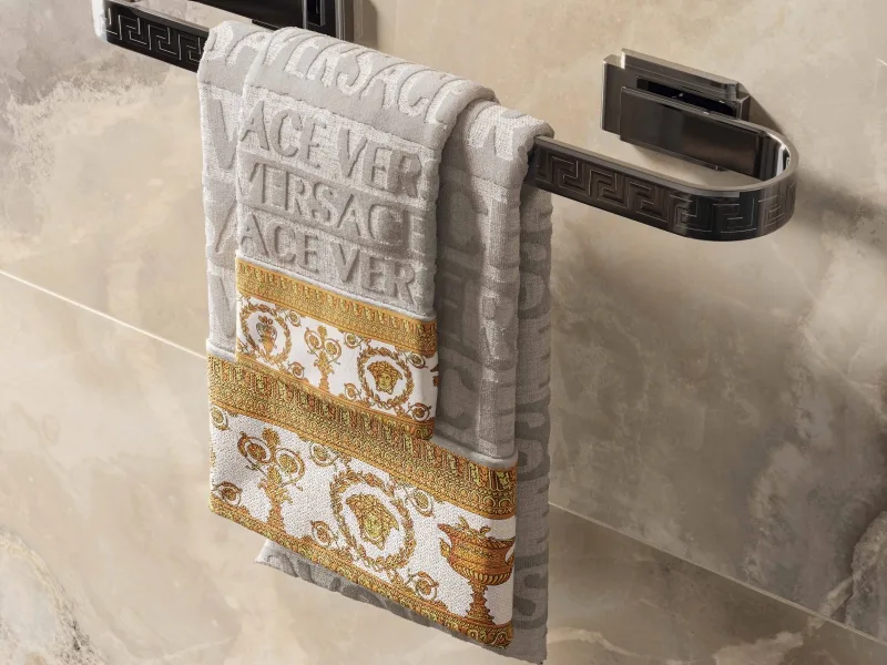 A chrome Greek towel rail, 60 cm, hung with Versace towels