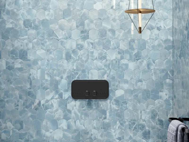 A Greek flush plate in black nickel on a blue onyx wall